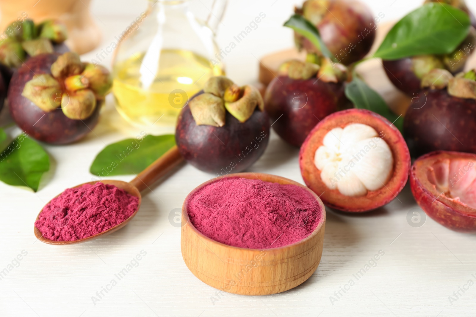 Photo of Purple mangosteen powder and fruits on white table