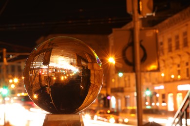 Photo of Beautiful city street, overturned reflection. Crystal ball at night. Space for text