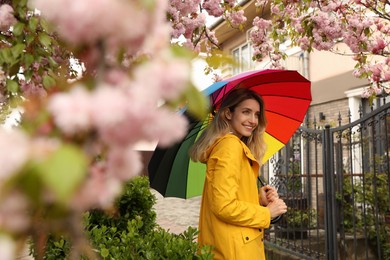 Young woman with umbrella in park on spring day