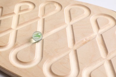 Wooden labyrinth balance board on white background, closeup. Montessori toy
