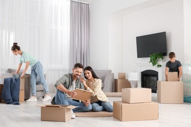 Photo of Happy family settling into new house and unpacking boxes. Moving day