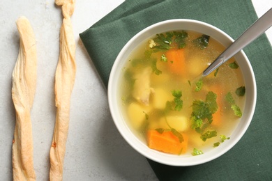 Photo of Bowl with delicious hot broth on table, top view. Cold treatment