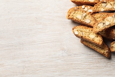 Traditional Italian almond biscuits (Cantucci) on white wooden table, flat lay. Space for text