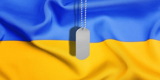 Image of Military ID tag and Ukrainian flag on background. Banner design