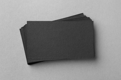 Blank black business cards on light background, top view. Mockup for design