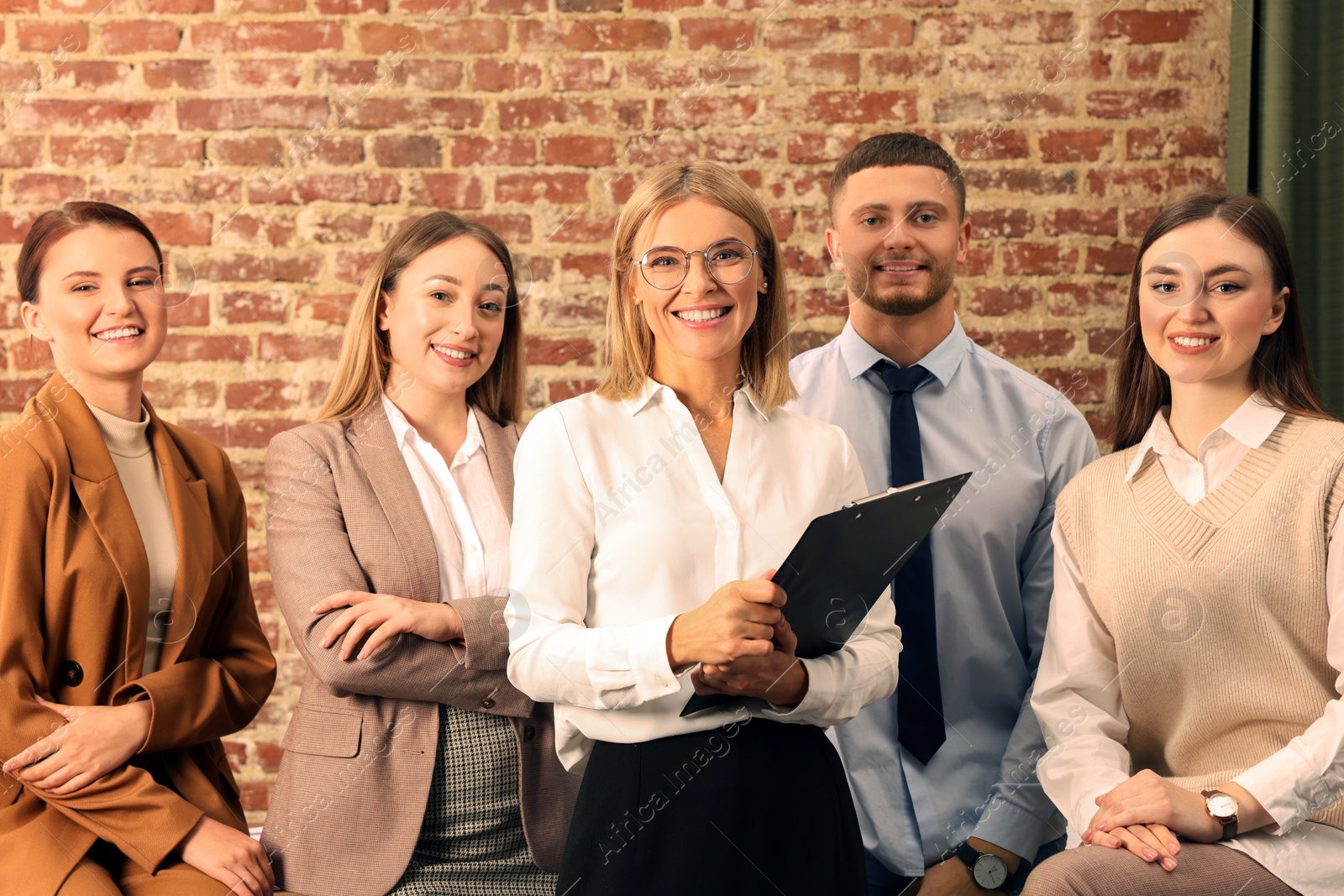 Photo of Businesswoman and her employees in office. Lady boss