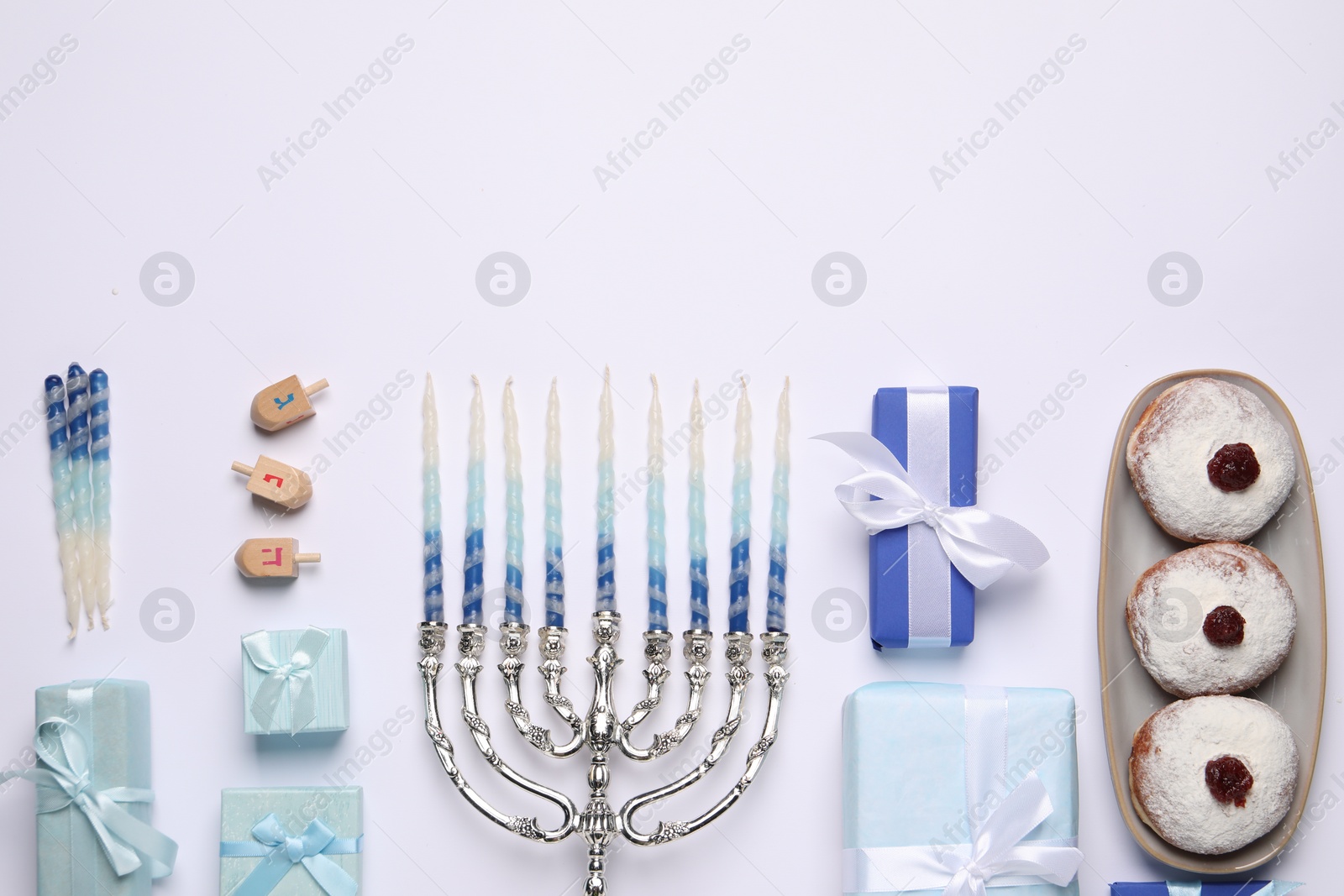 Photo of Flat lay composition with Hanukkah menorah and gift boxes on light background. Space for text