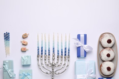 Flat lay composition with Hanukkah menorah and gift boxes on light background. Space for text