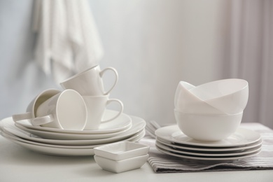 Set of clean dishware on white table indoors