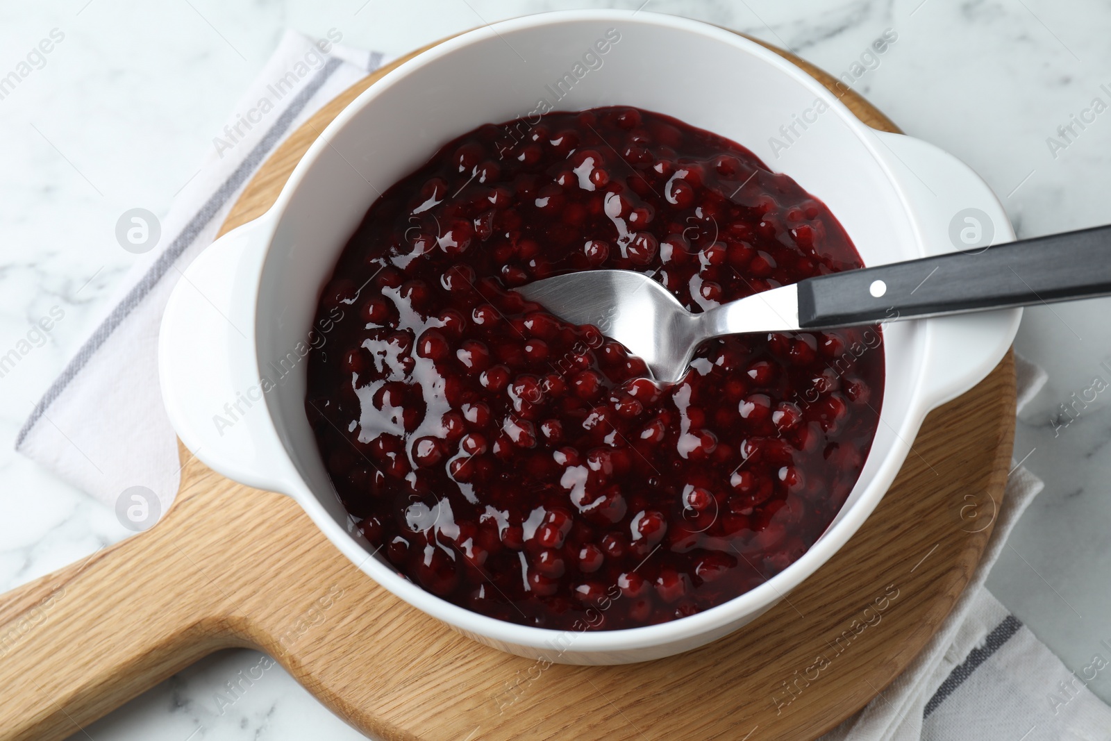 Photo of Fresh cranberry sauce in bowl served on white table, above view