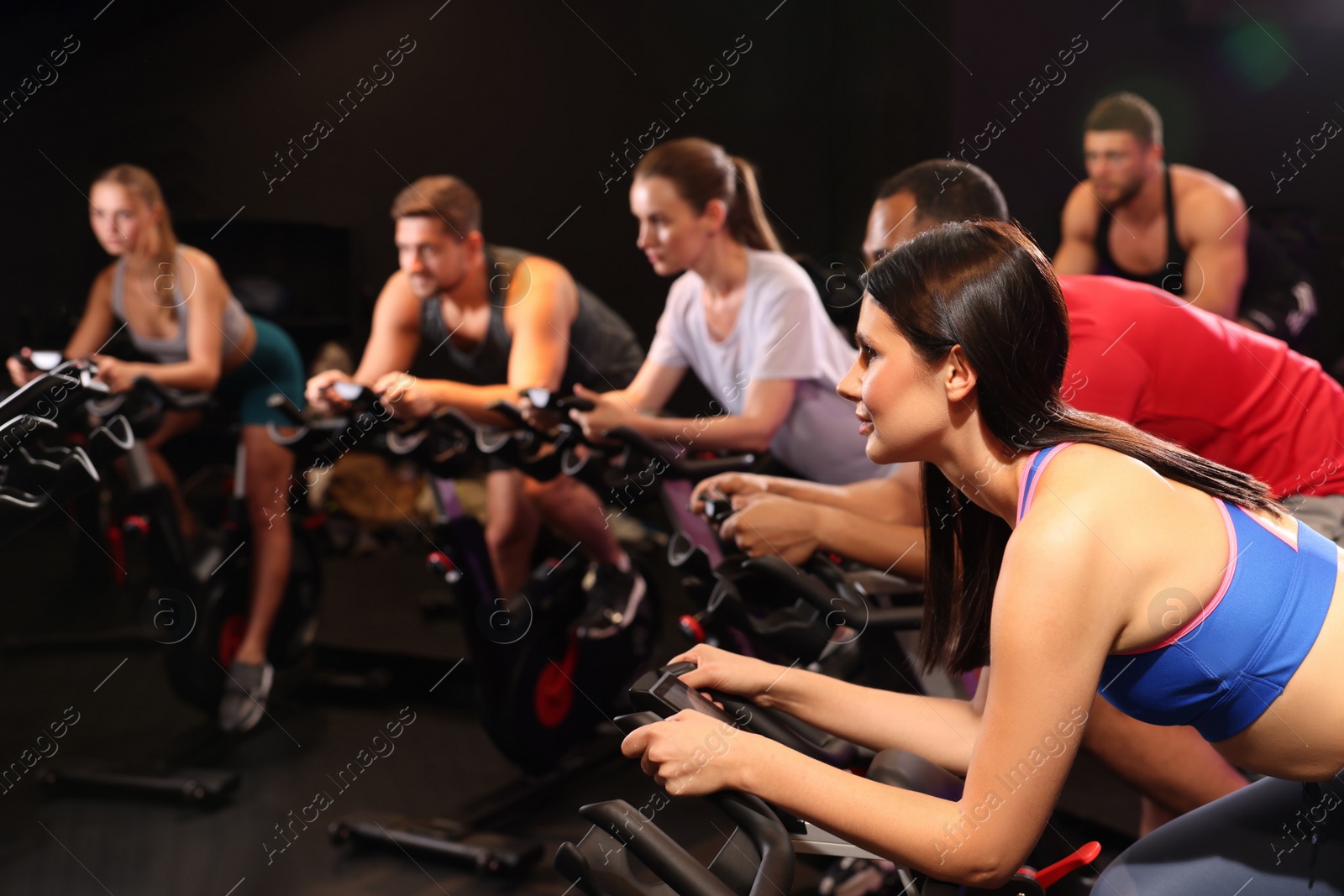 Photo of Group of people training on exercise bikes in fitness club