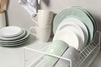 Many different clean dishware and cups on white table indoors