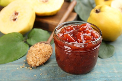 Delicious quince jam on light blue wooden table, closeup