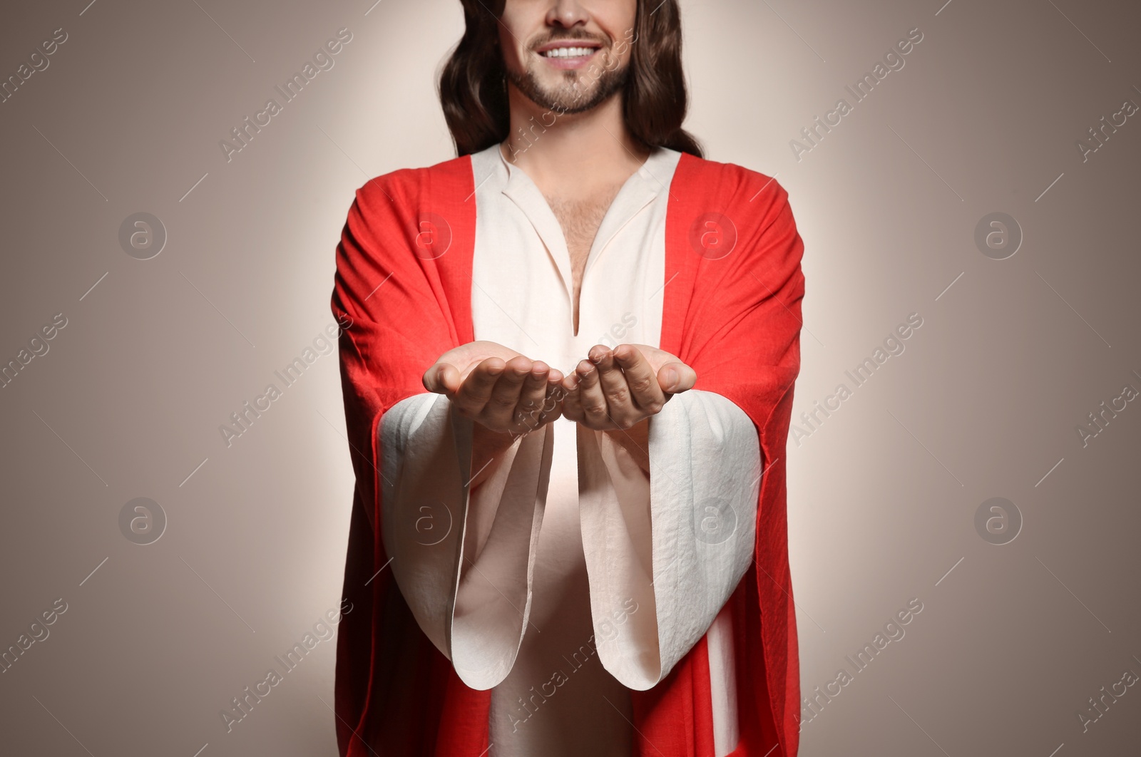 Photo of Jesus Christ reaching out his hands on beige background, closeup