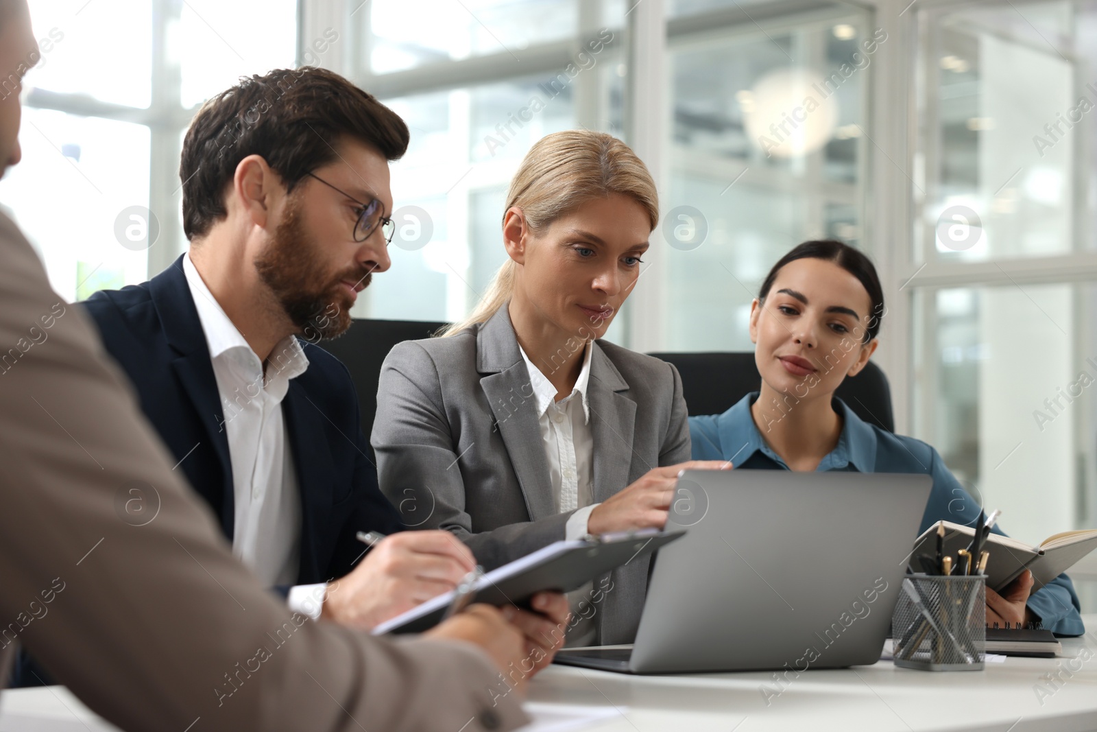 Photo of Lawyers working together with laptop at table in office