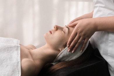 Photo of Cosmetologist making face massage to client in clinic, closeup