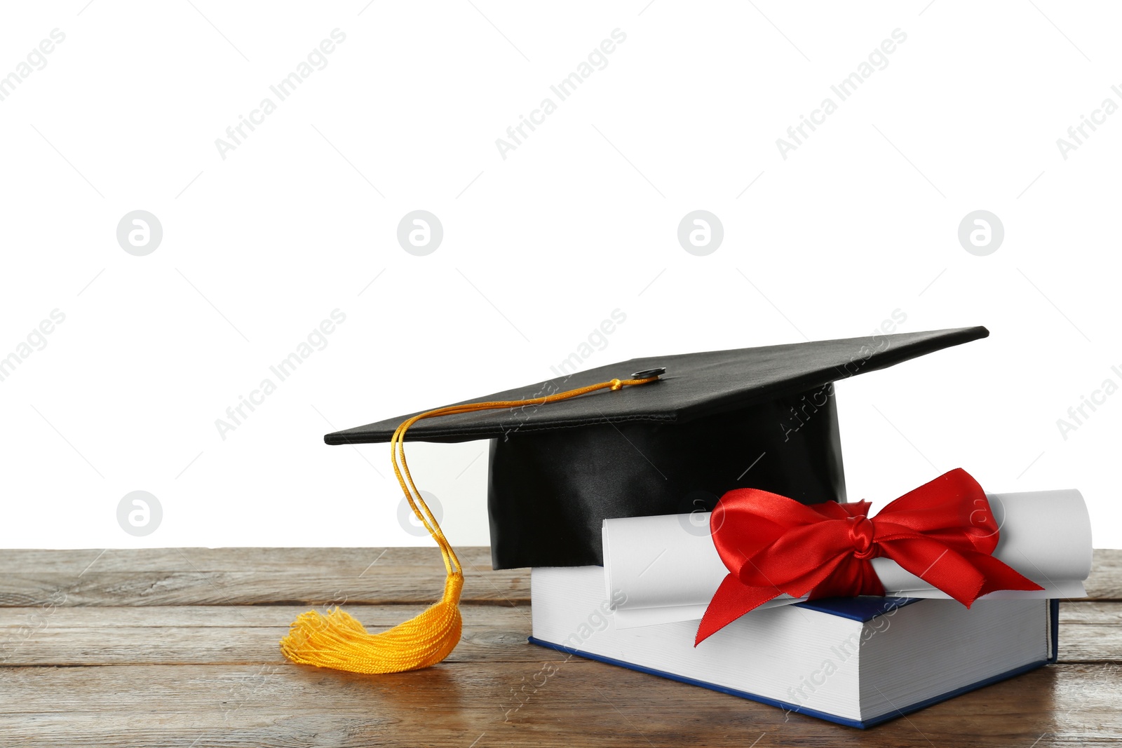 Photo of Graduation hat, book and diploma on wooden table against white background