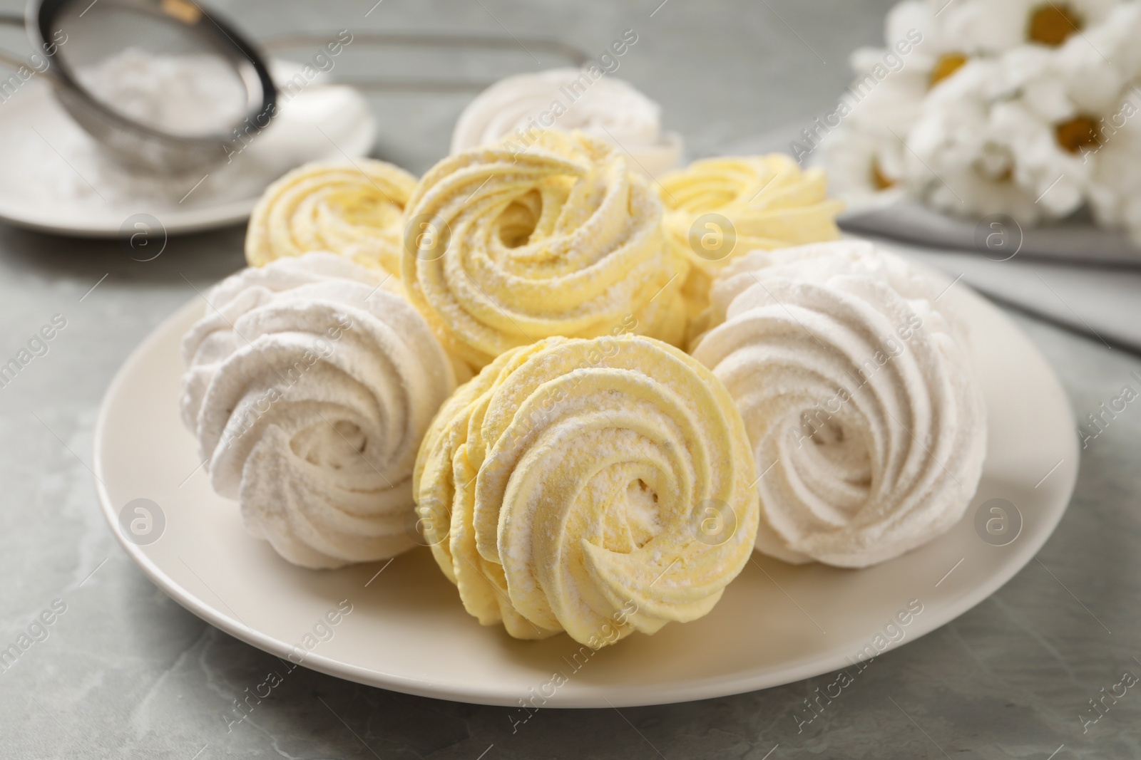 Photo of Delicious white and yellow marshmallows on grey marble table