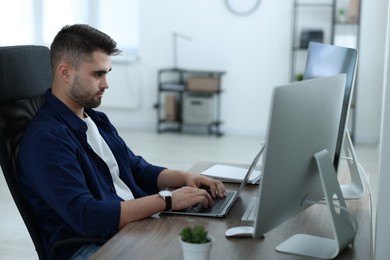 Young programmer working at desk in office