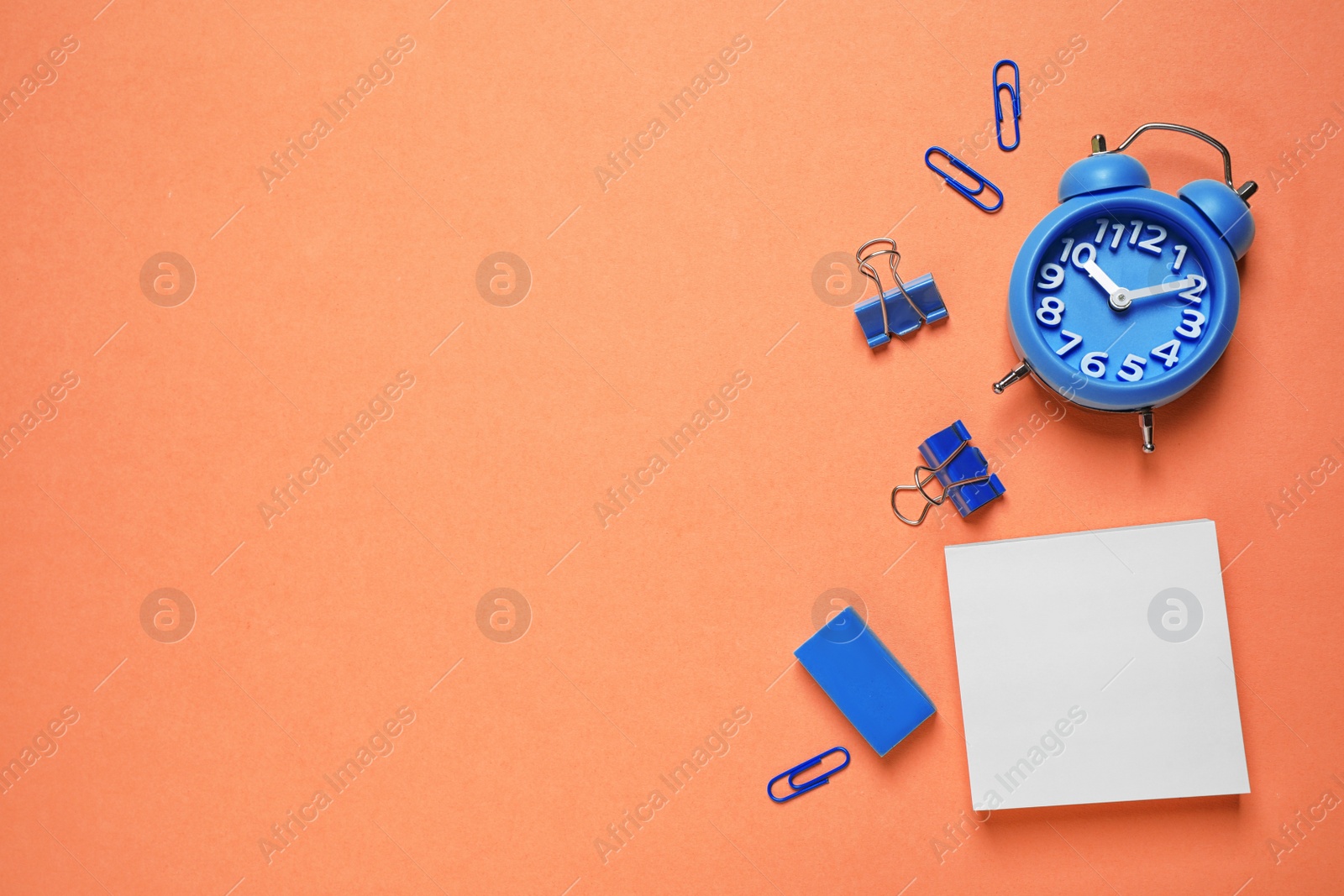 Photo of Flat lay composition inspired by color of the year 2020  (Classic blue) on orange background. Space for text