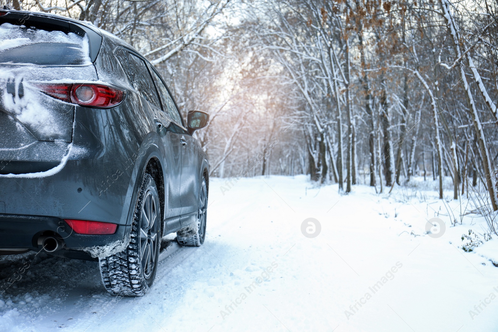 Photo of Snowy country road with car on winter day. Space for text