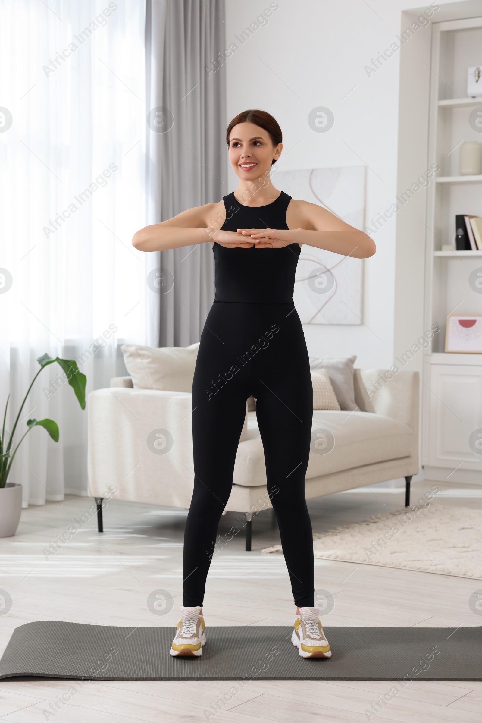 Photo of Happy woman doing morning exercise at home