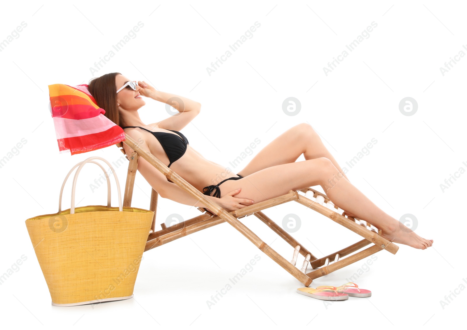 Photo of Young woman with beach accessories on sun lounger against white background