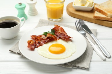 Delicious breakfast with sunny side up egg served on white wooden table