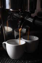 Photo of Making fresh aromatic espressos using professional coffee machine in cafe, closeup