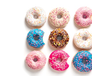 Photo of Delicious doughnuts with sprinkles on light background, top view