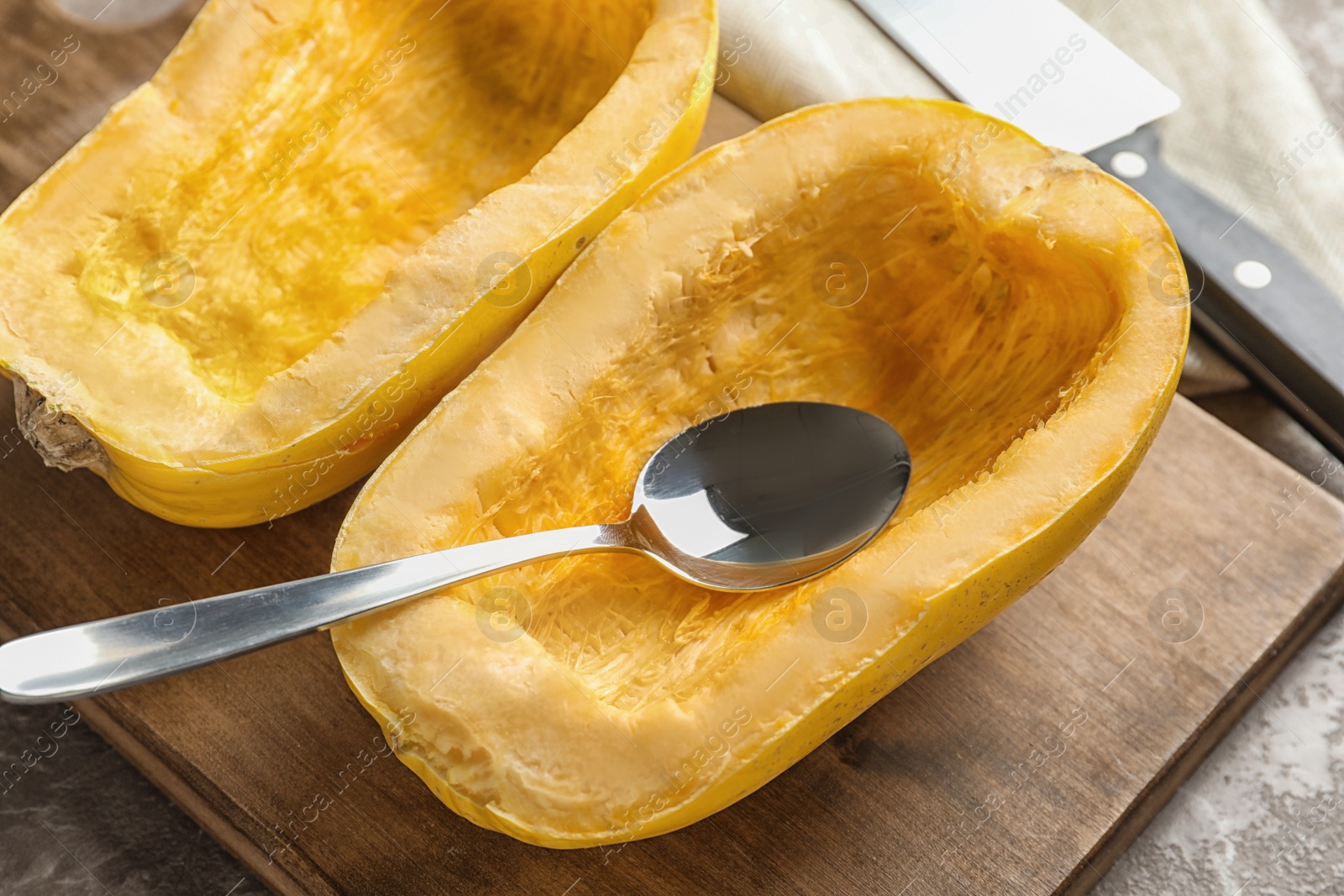 Photo of Wooden board with cut spaghetti squash on table