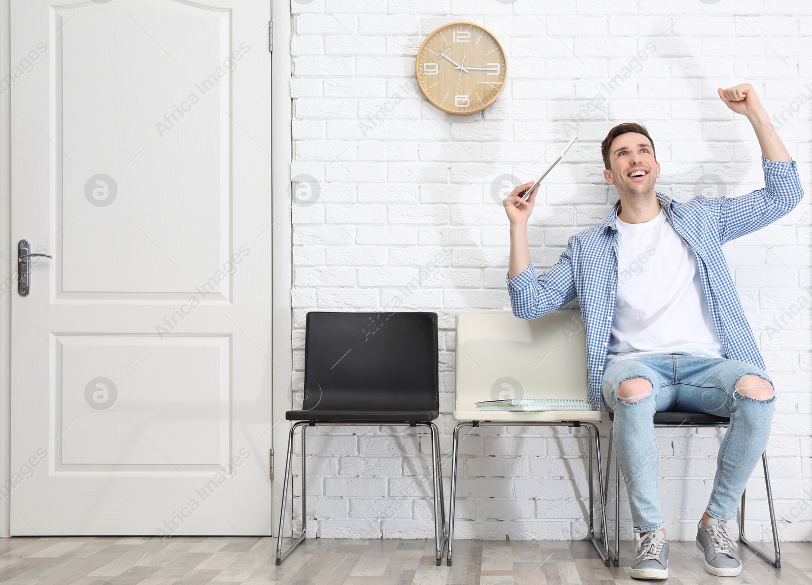 Photo of Young man being happy after success job interview, indoors