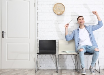 Young man being happy after success job interview, indoors