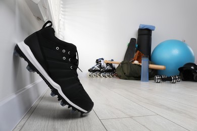 Black snickers and different sports equipment indoors