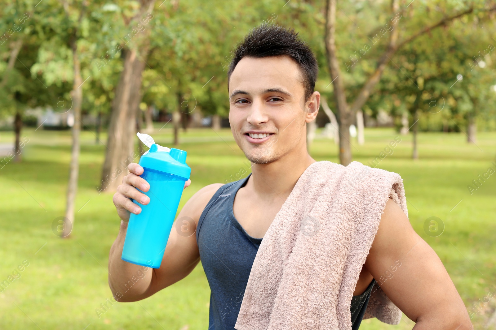 Photo of Man with bottle of protein shake in green park