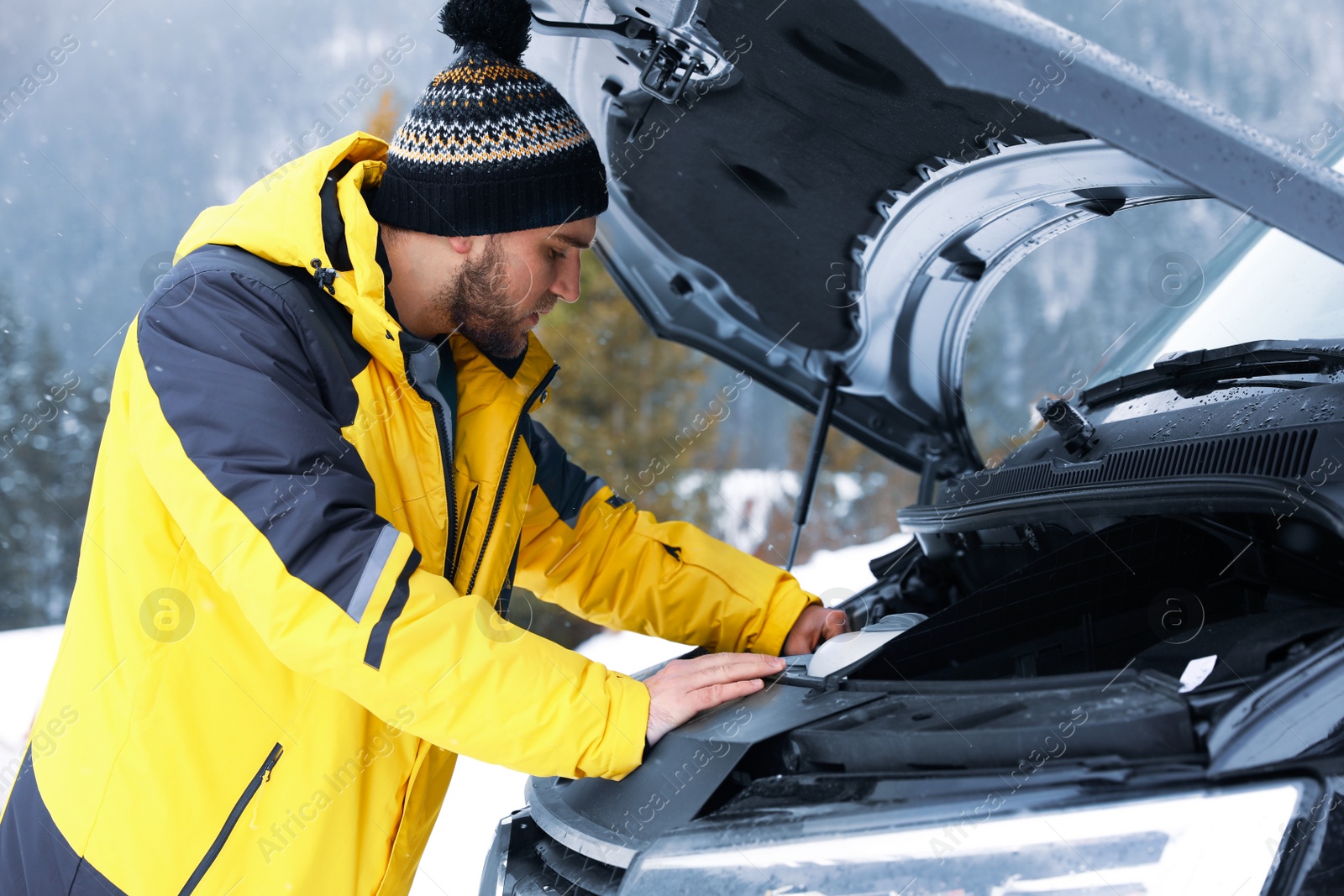 Photo of Stressed man near broken car outdoors on winter day