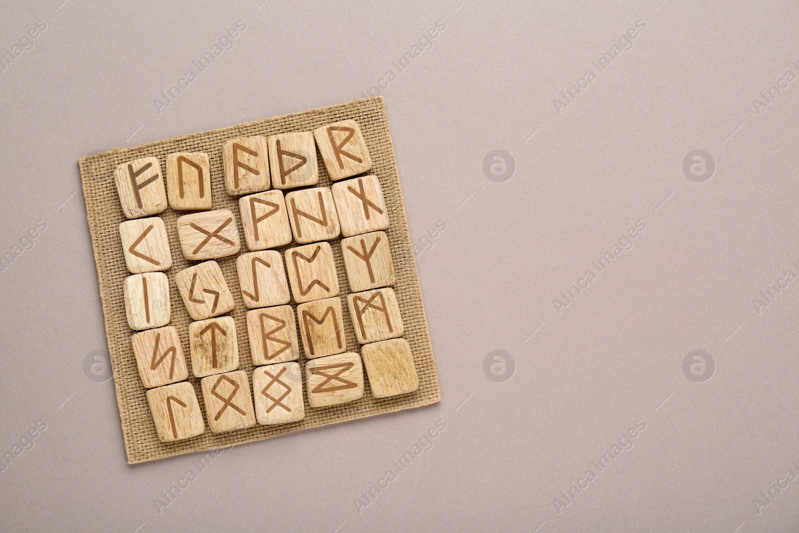 Photo of Wooden runes on light grey background, top view. Space for text