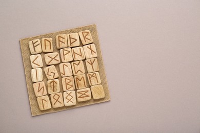 Photo of Wooden runes on light grey background, top view. Space for text