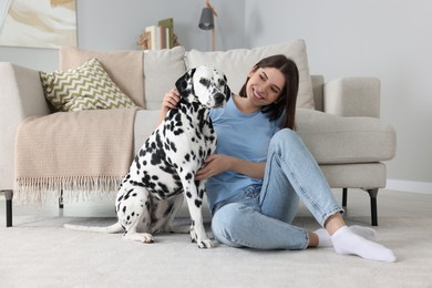 Happy young woman with her adorable Dalmatian dog at home. Lovely pet