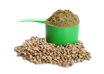 Scoop with hemp protein powder and seeds on white background