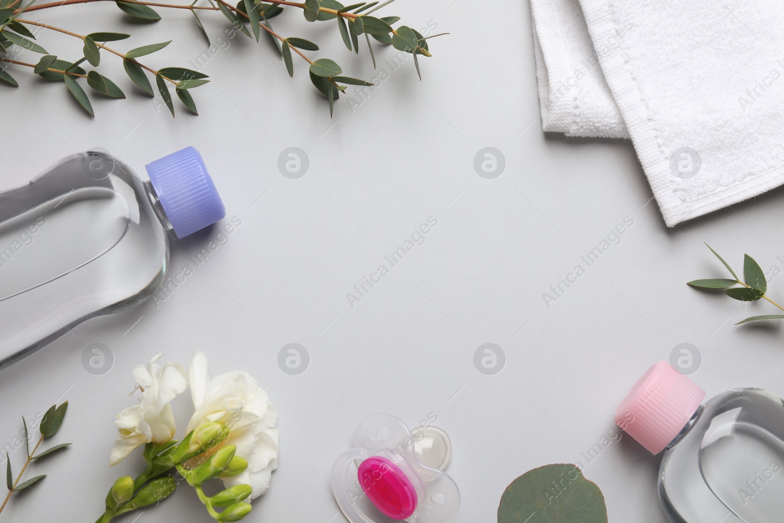 Photo of Frame of baby oil, plants and accessories on light grey background, flat lay