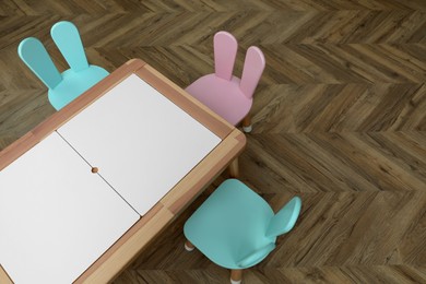 Photo of Small table and chairs with bunny ears in children's room