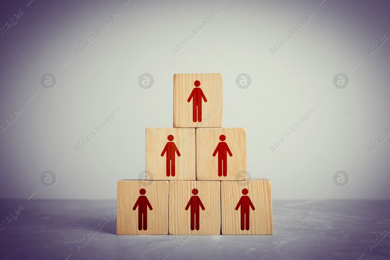 Image of Team and management concept. Pyramid of wooden cubes with human icons on table