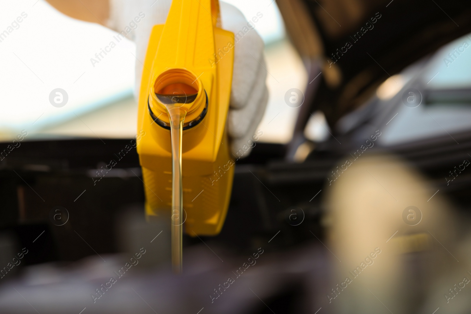 Photo of Man pouring motor oil from yellow container, closeup. Space for text