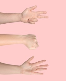 People playing rock, paper and scissors on pink background, closeup