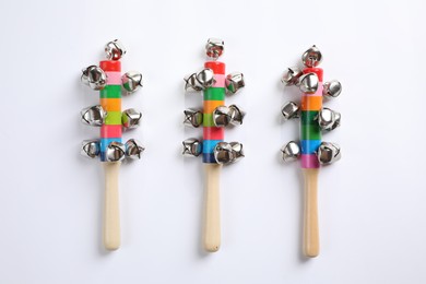 Photo of Wooden shakers with bells on white background, top view. Montessori musical toy