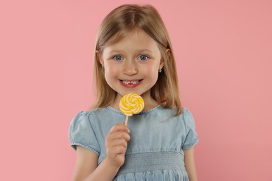 Photo of Portrait of happy girl with lollipop on pink background