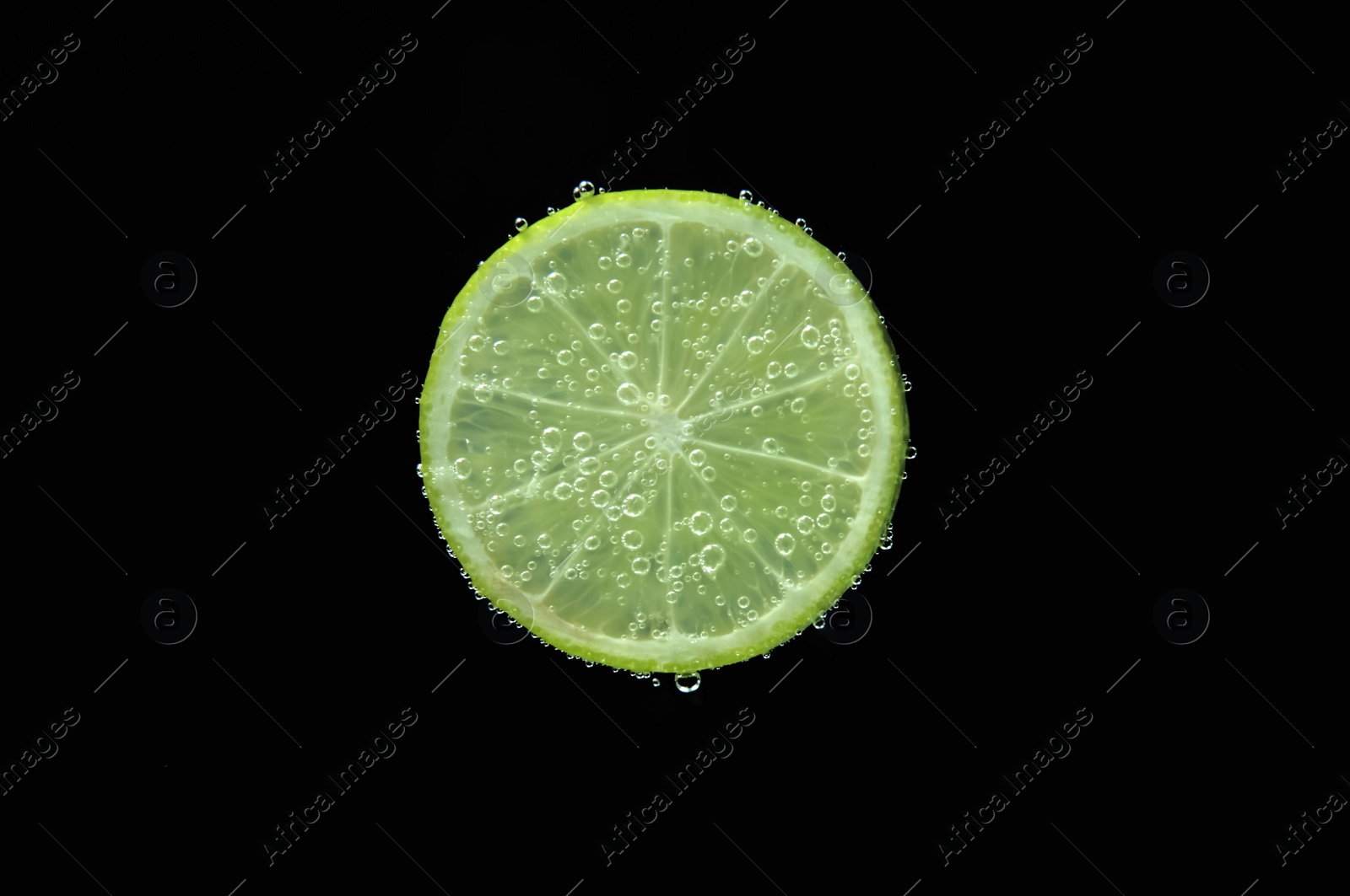 Photo of Slice of lime in sparkling water on black background. Citrus soda