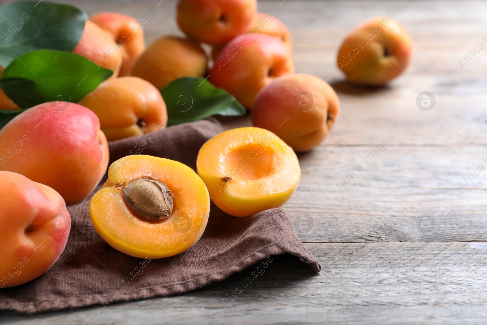 Photo of Delicious fresh ripe apricots on wooden table. Space for text