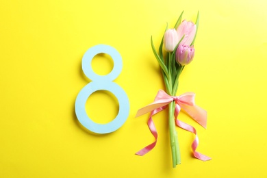 Photo of 8 March card design with tulips on yellow background, flat lay. International Women's Day